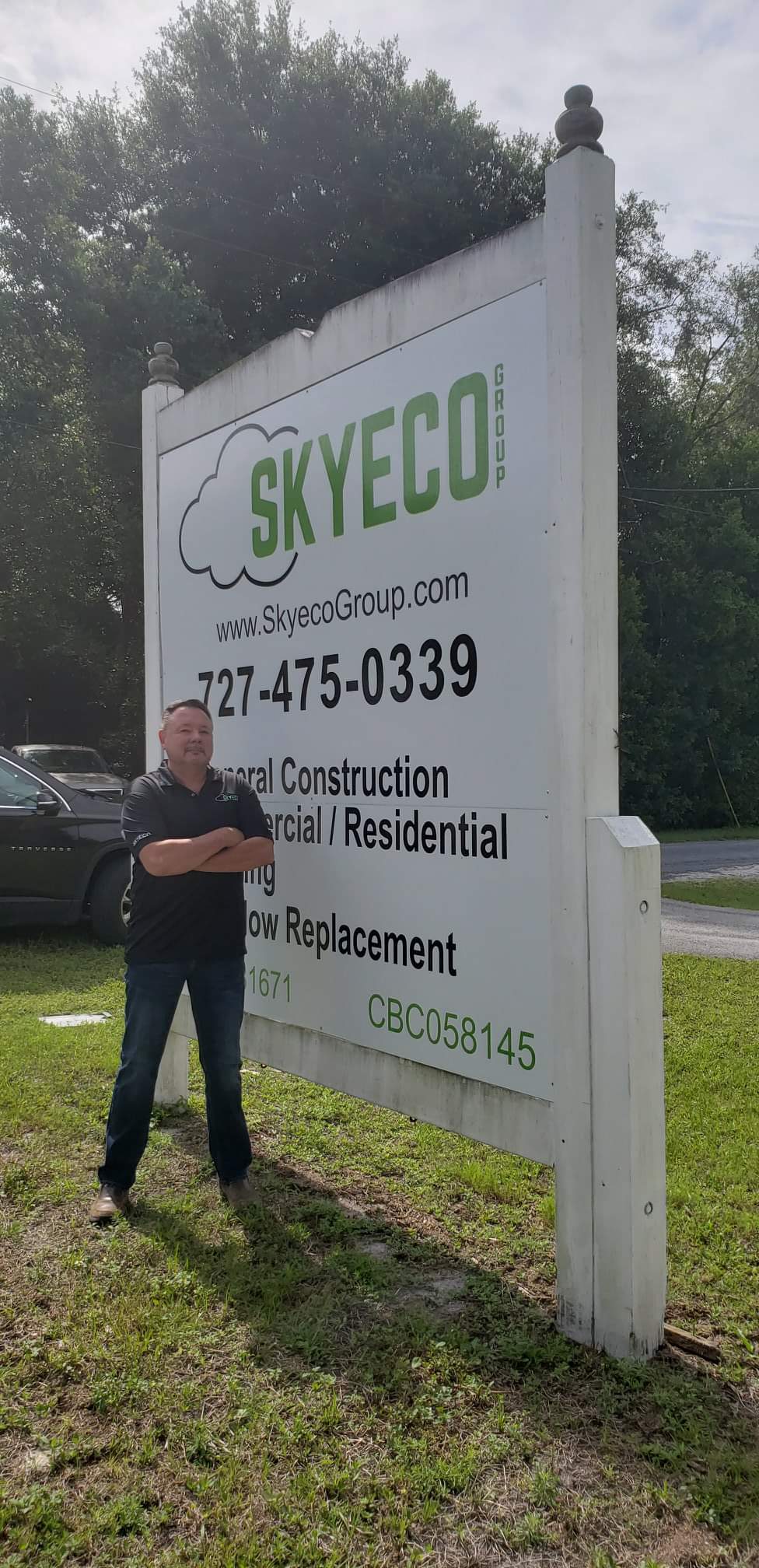 A man standing in front of a sign.